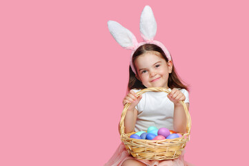 Happy smiling girl with Easter bunny  headband with  her basket with eggs