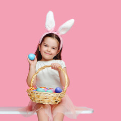 wearing bunny ears presenting blue Easter egg in her hand