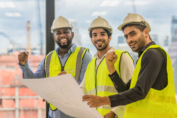 three civil engineer standing together raise fist up to show teamwork and confident