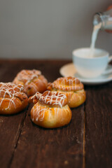 A delicate choux pastry filled with whipped cream, topped with a crispy craquelin layer and a chocolate garnish, isolated on a white background