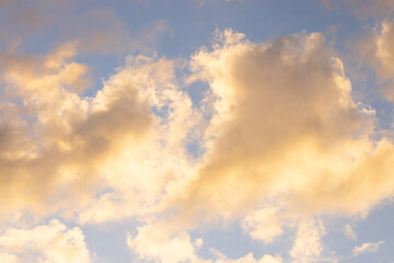 Loose, fluffy clouds in the golden evening light just before sunset