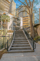Fototapeta na wymiar Stairs going up a building overlooking the canal in San Antonio River Walk Texas