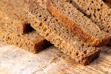 Sliced piece of black rye bread on a board