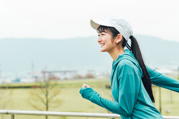 健康管理のため公園を笑顔で有酸素運動するスポーツウェアの元気なアジア人女性
 - obrazy, fototapety, plakaty