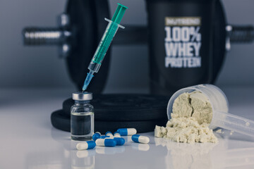 dumbbell, syringe with needle, pills and vial with steroids and whey powder in scoop. illegal doping in sport concept. loss weigh or build muscle. 