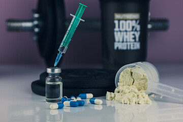 dumbbell, syringe with needle, pills and vial with steroids and whey powder in scoop. illegal...