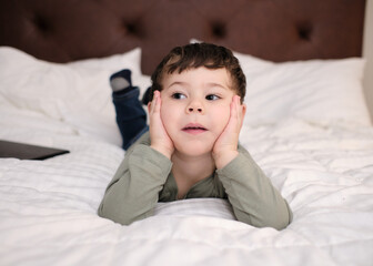 cute young boy on the bed in the hotel room