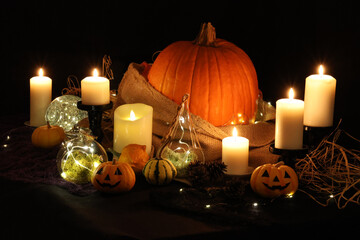 ハロウィンの飾り付け　キャンドルの光に灯されたお化けカボチャやジャックオーランタン　ハロウィーンのイメージ