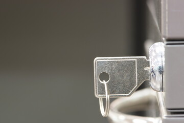 Key in office filing cabinet lock concept side view closeup copy space selective focus.	