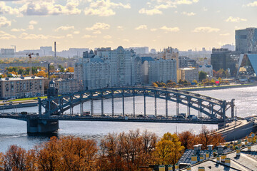 Obraz premium Iron bridge across the river within the city. City view on an autumn sunny day.