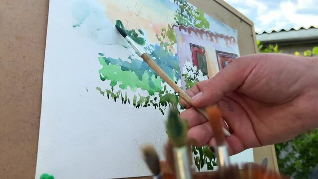 many different brush tips against the background of the painting that the artist is currently painting there is a photo where the artist actually paints. High quality photo