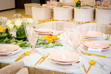 Decoración en tono rosado de mesa en fiesta con vajilla y cristalería