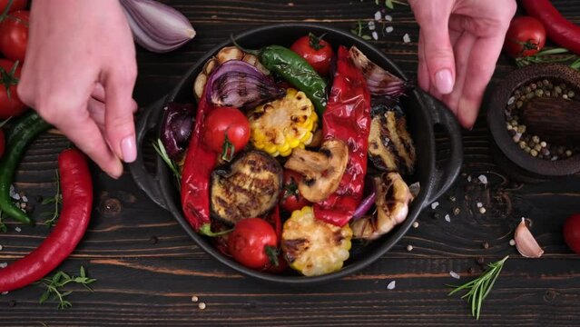 woman putting plate with sliced grilled vegetables onto kitchen table
