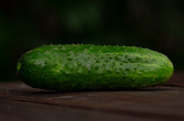 Green cucumber on a wooden table close-up