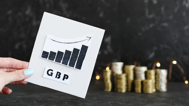 currency exchange rate, graph showing positive growth with GBP British pound text in front of stacks of coins