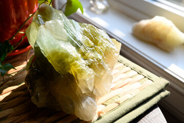 An image of a large green calcite crystal in bright sun light.