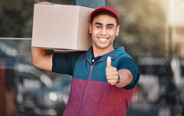 Portrait, box and delivery worker with thumbs up gesture and a big smile carrying cargo, stock or a...