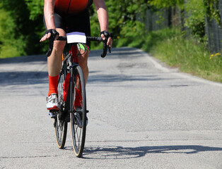 Fototapeta na wymiar cyclist with bike rides fast on the asphalt road