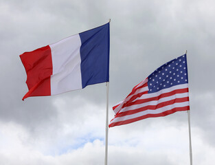 two American and French flags waving together as a sign of collaboration