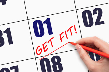 1st day of the month.  Hand writing text GET FIT and drawing a line on calendar date. Save the date.