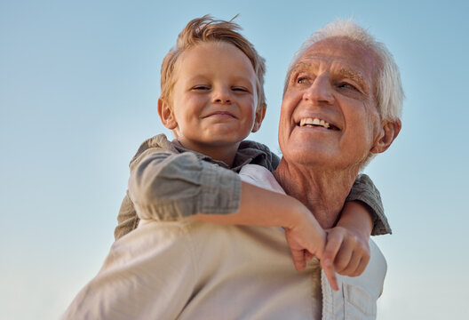 Piggyback, Child And Grandfather With Smile In Nature For Freedom, Love And Relax With A Blue Sky. Portrait Of A Young, Happy And Playful Kid Being Funny, Bonding And Crazy With A Senior Man In Park