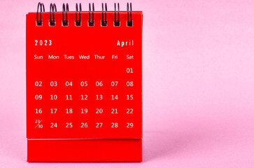 The Red April 2023 Monthly desk calendar for 2023 year on pink background.
