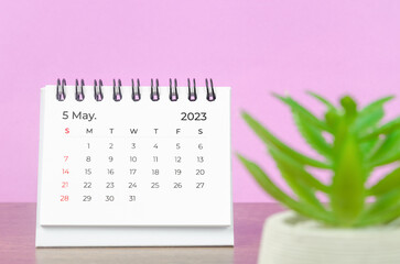 The May 2023 Monthly desk calendar for the organizer to plan 2023 year on wooden table background.