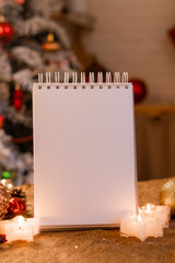 Naklejka na ściany i meble notebook with empty pages on a wooden table in the kitchen against the background of a Christmas tree. New Year's recipes. space for text. High quality photo