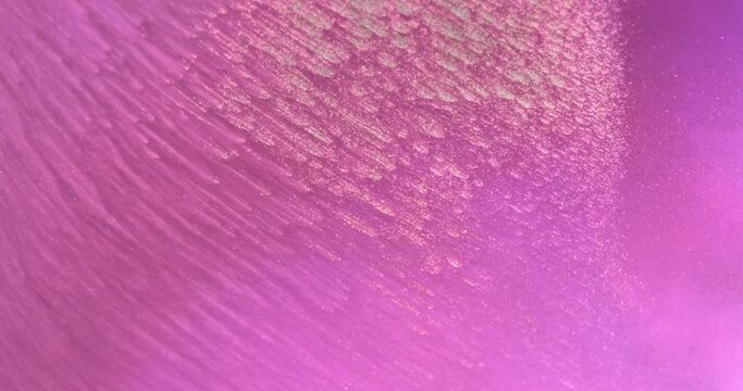 Pink gold paint abstract flow background. Diagonal lines bright magenta ink motion. Shiny gold particles in liquid. Bright color art. Fluid backdrop. Acrylic move pattern texture. Golden pink artwork