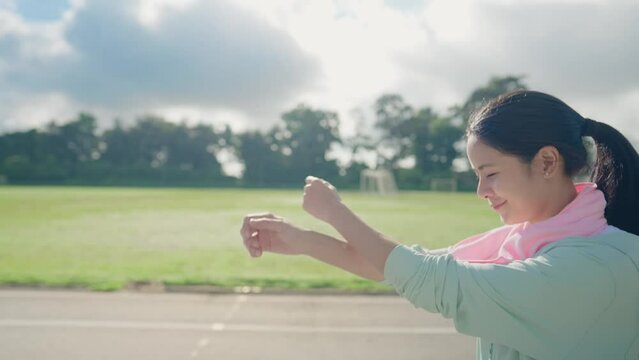 Side view of young asian woman cooldown after finish with morning exercise, fresh air and morning sunlight, swinging arms warming up body temperature before workout, self discipline for good health