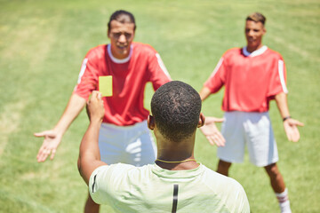 Soccer, team and referee with yellow card, booking and foul a player on a grass pitch or field...