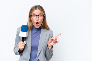 Young TV presenter caucasian woman isolated on white background surprised and pointing side