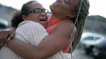 Fototapeta premium Young Brazilian adult daughter hugging elderly mother. South American people showing affection and love 2