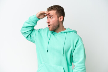 Fototapeta premium Young handsome caucasian man isolated on white background with surprise expression while looking side