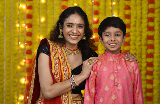 Happy young woman and her son celebrating diwali stock images 