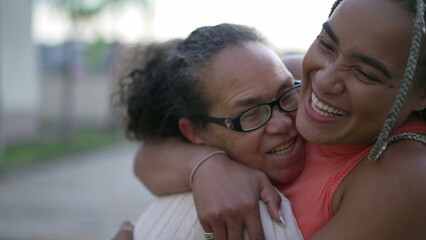 Brazilian adult daughter hugging senior mother showing love and affection. A caring black woman...