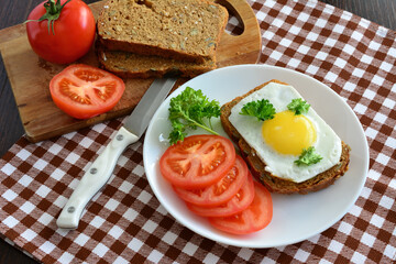 healthy toast with fried egg and tomato slices, close-up