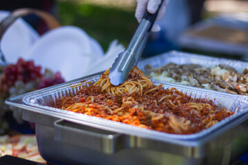 Preparation of italian food outside pizza spagetti and salad