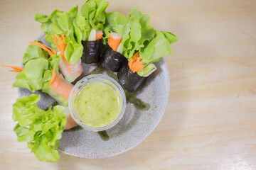 Fototapeta na wymiar Fresh vegetable salad rolls with sea food saurce.