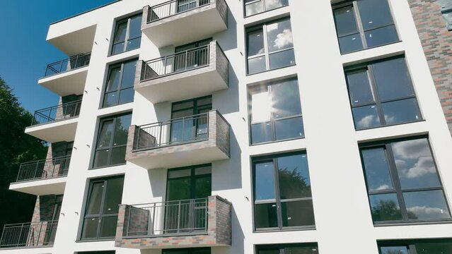 The facade of a modern high-rise building. Newly built modern residential building with panoramic windows.