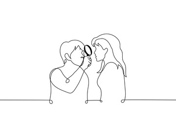 man looks at a woman through a magnifying glass - one line drawing vector. concept a man studies a woman, an interested man drew attention to a woman, a man's love