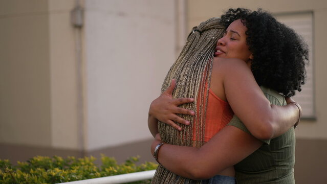 Female friend consoling desperate young woman. Two black sisters supporting each other. Friends embrace in crisis