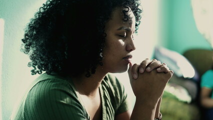 African American woman praying to God. A spiritual black hispanic girl in prayer having HOPE and...