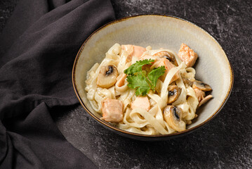 pasta with salmon on a dark background