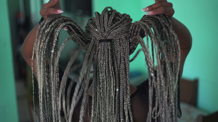 One young black latina woman showing her long braided hairstyle. An African American girl with beautiful box braids hair