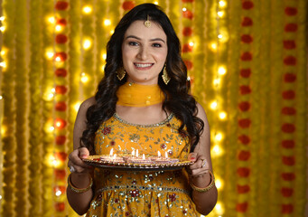 Happy young woman celebrating diwali 