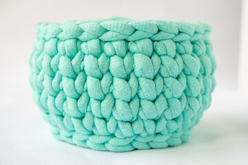 close-up of a beautiful cozy bright blue crochet basket, organizers of various small things, jewelry storage. a nice hobby in the winter evenings. Sustainable, organic lifestyle advertising.