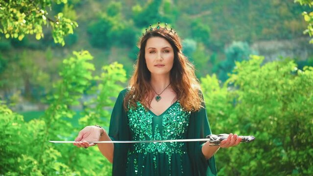 Fantasy portrait warlike red-haired woman queen holding silver sword in hands praying before battle. ritual of sacrifice. Green silk dress long elven sleeves, golden crown emeralds gems medieval style