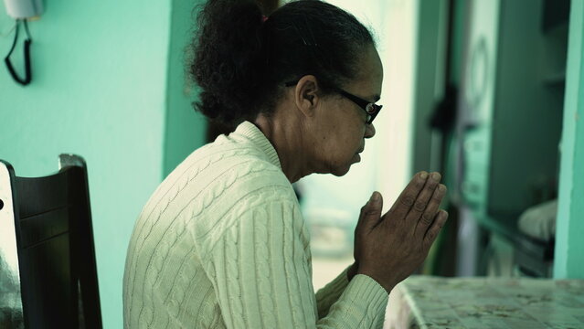 One Hopeful Black Senior Woman Praying To God. A Spiritual Latin South American Older Lady Prays