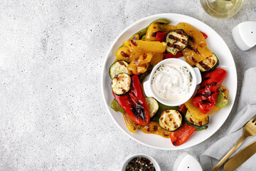 Grilled vegetable: bell pepper and zucchini on a white plate and grey background. Top view, copy space.